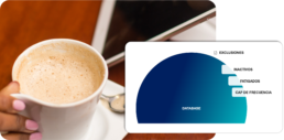 Persona con una tablet sosteniendo un caf&eacute;, con un diagrama de la base de datos y sus exclusiones: inactivos, fatigados y cap de frecuencia.